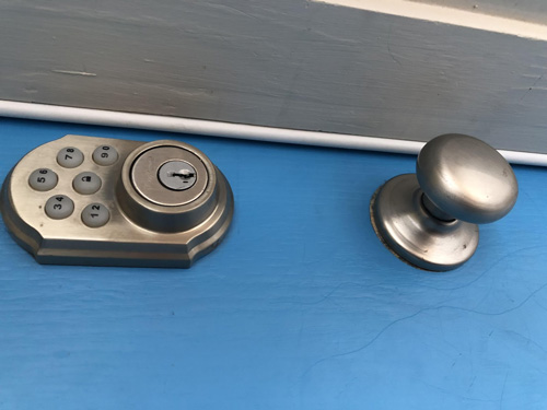 Deadbolt and door knob on a blue door